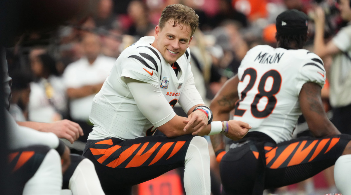 Joe Burrow kneels resting his arm on one leg